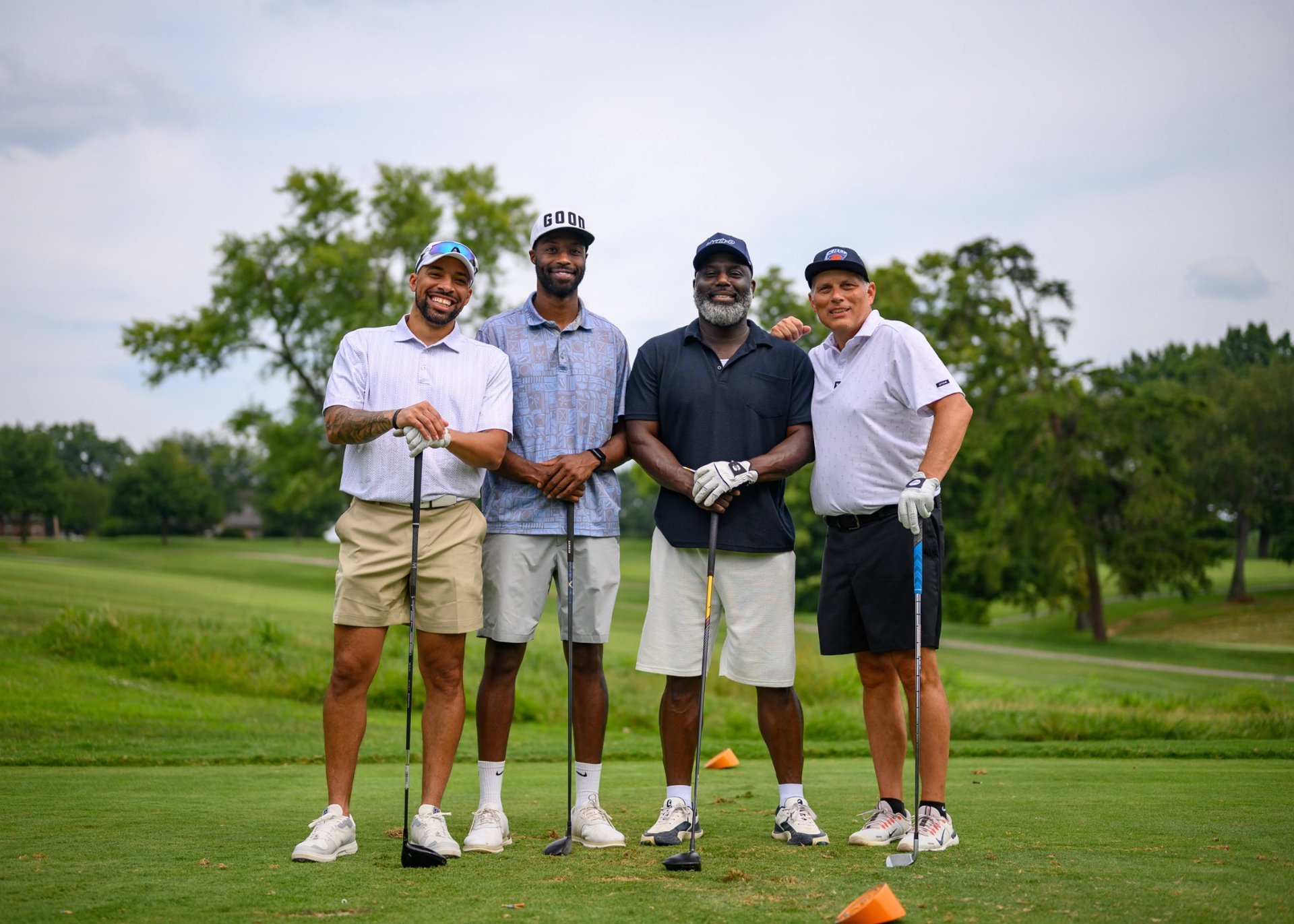 A golf team together on the course at the Invitational Golf Scramble