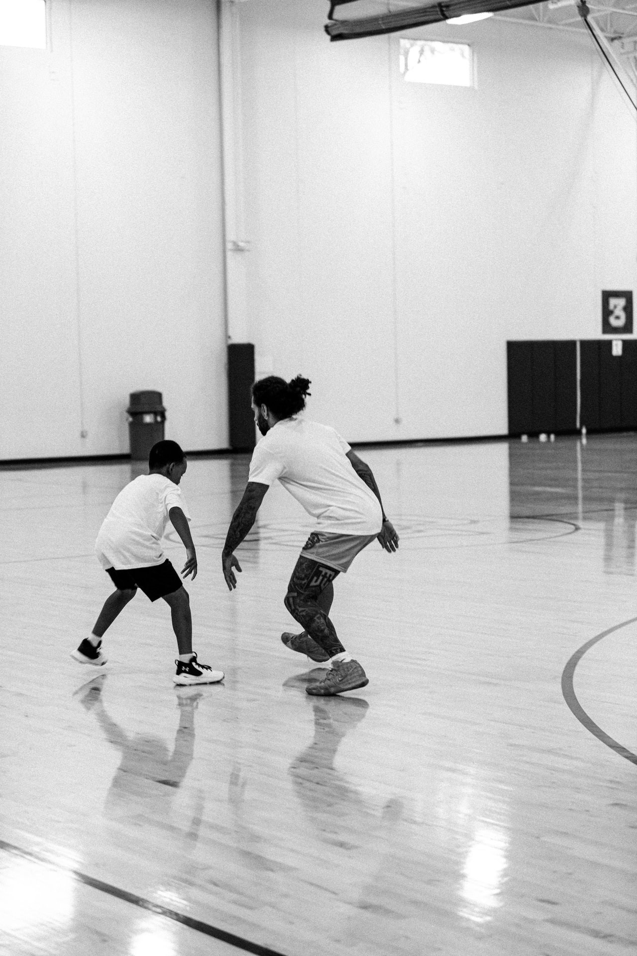 A coach guiding a young player on the basketball court